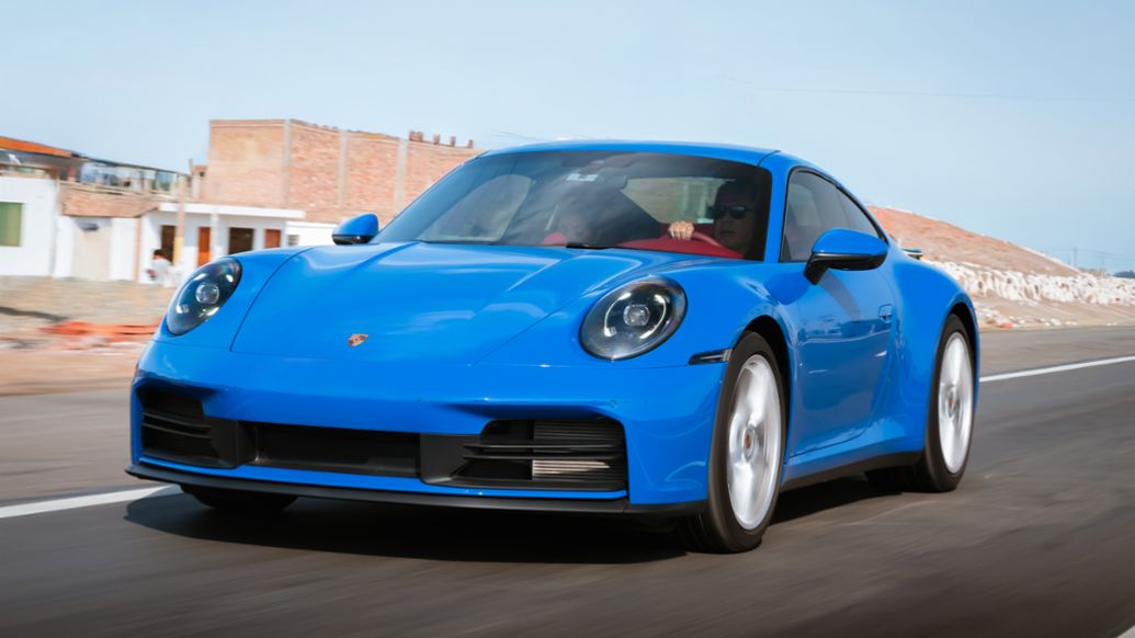 El Porsche 911 azul claro en acci&oacute;n, imponiendo su elegancia y potencia en el Driven Summer Experience. Lima, Per&uacute;, Porsche AG.